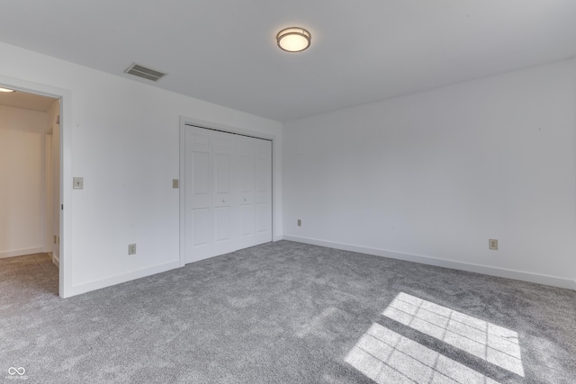 unfurnished bedroom with visible vents, baseboards, carpet floors, and a closet