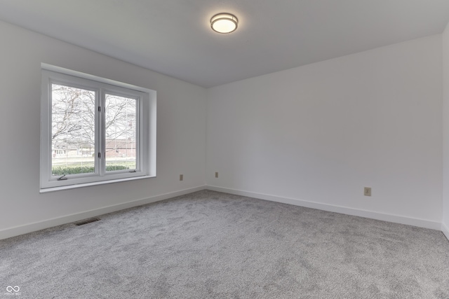 empty room with visible vents, carpet floors, and baseboards