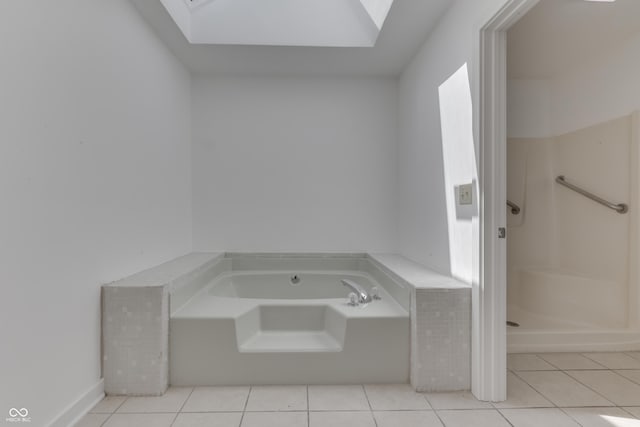 bathroom with tile patterned floors, a skylight, a garden tub, and a stall shower