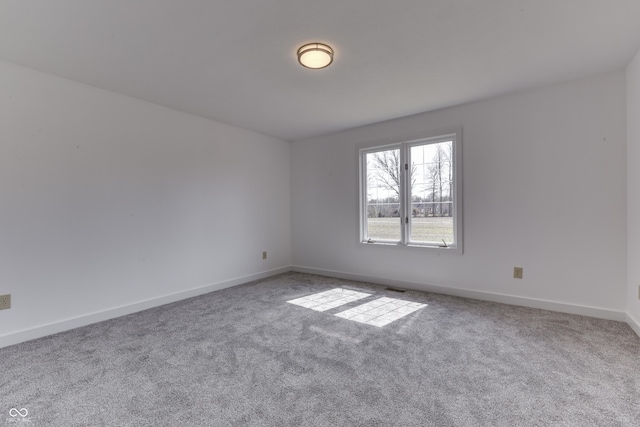 carpeted spare room with visible vents and baseboards