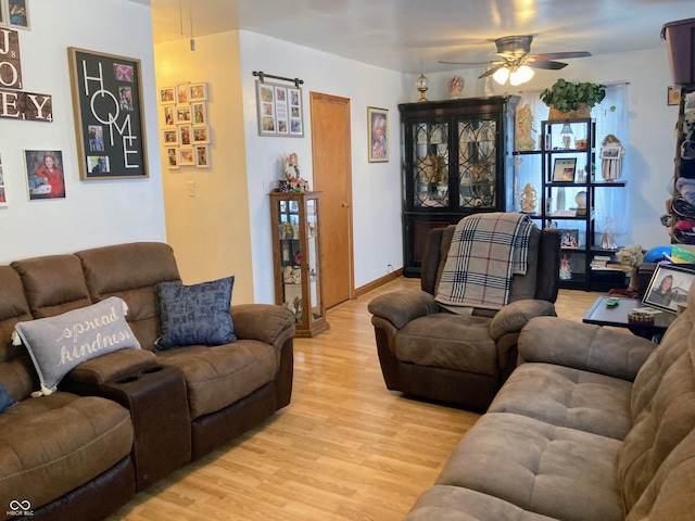 living room featuring ceiling fan and light hardwood / wood-style floors