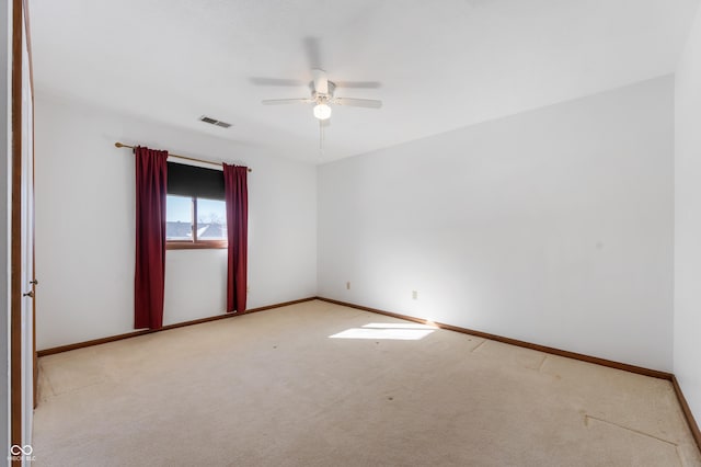 spare room featuring ceiling fan and light colored carpet