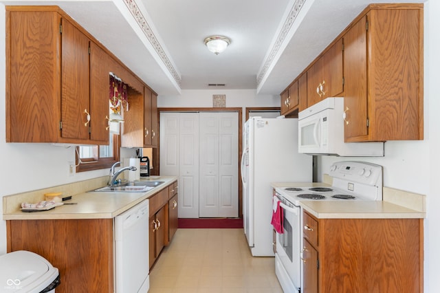 kitchen with crown molding, sink, and white appliances