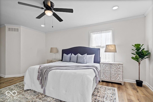 bedroom featuring ceiling fan, light wood-type flooring, and crown molding