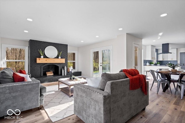 living room featuring light hardwood / wood-style flooring, french doors, and a fireplace