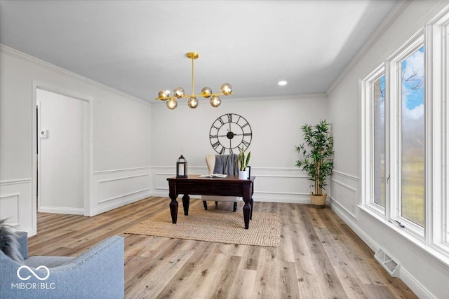 office featuring ornamental molding, a notable chandelier, and light wood-type flooring