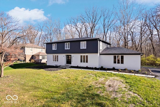 rear view of house featuring a lawn