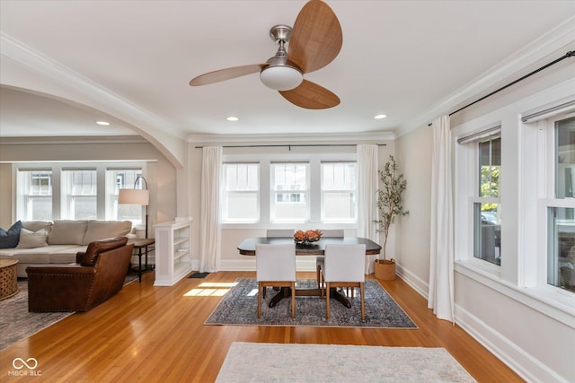 dining room with a healthy amount of sunlight, ornamental molding, and light hardwood / wood-style floors