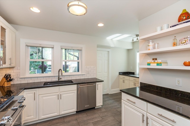 kitchen with appliances with stainless steel finishes, white cabinets, and sink