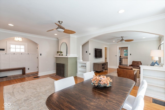 dining room featuring light hardwood / wood-style floors, ceiling fan, and crown molding