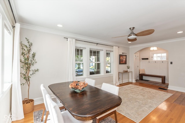 dining area with ceiling fan, crown molding, and light hardwood / wood-style flooring