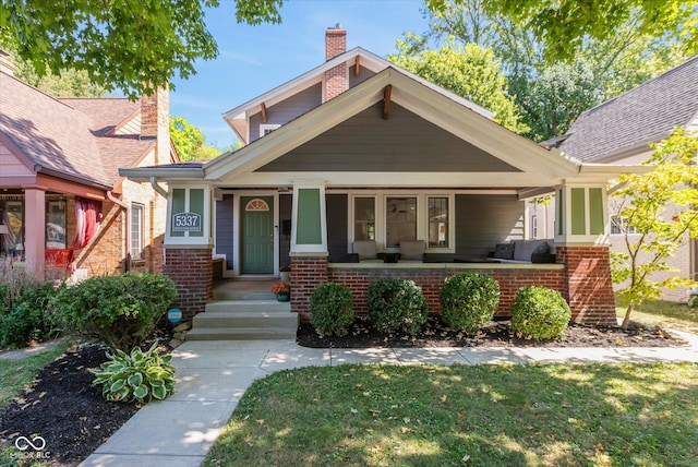 view of front of house featuring covered porch and a front yard