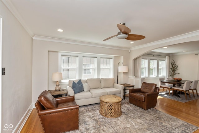 living room with wood-type flooring, ceiling fan, and crown molding