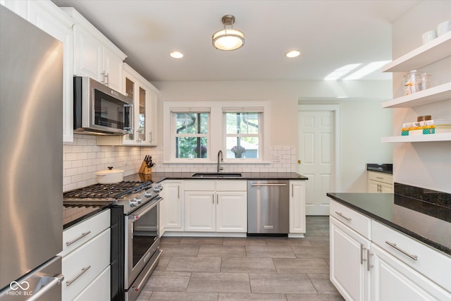 kitchen featuring stainless steel appliances, white cabinets, decorative backsplash, and sink