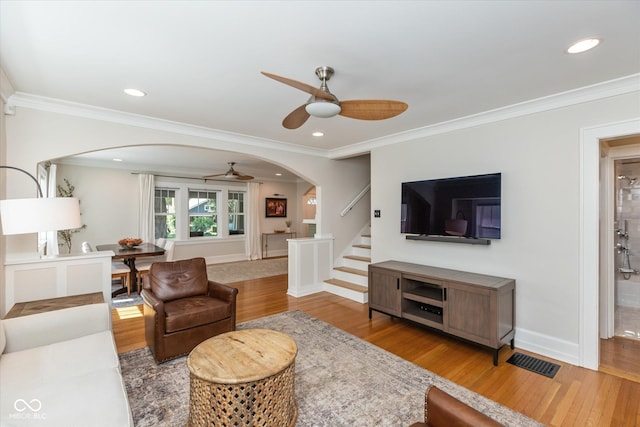 living room with ornamental molding, ceiling fan, and hardwood / wood-style flooring