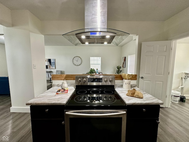 kitchen featuring electric stove, light hardwood / wood-style floors, island range hood, and a center island