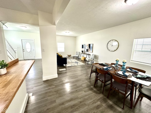 dining area featuring a textured ceiling, dark hardwood / wood-style floors, and plenty of natural light