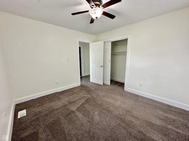 unfurnished bedroom featuring ceiling fan, a closet, and dark carpet