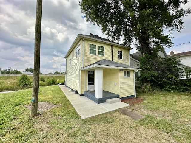 rear view of house with a patio area and a lawn