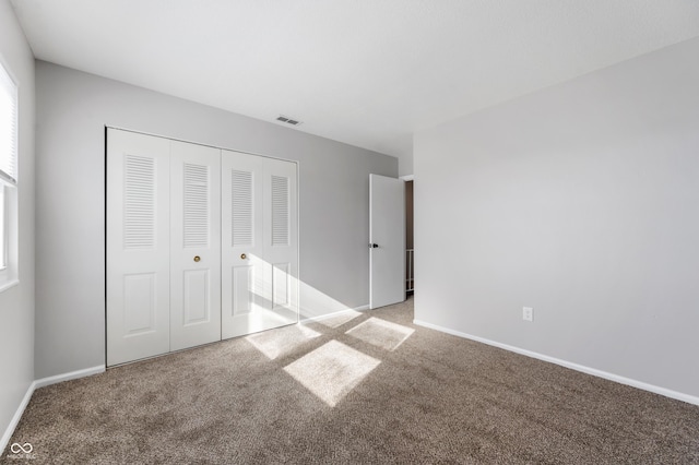 unfurnished bedroom with carpet floors and a closet