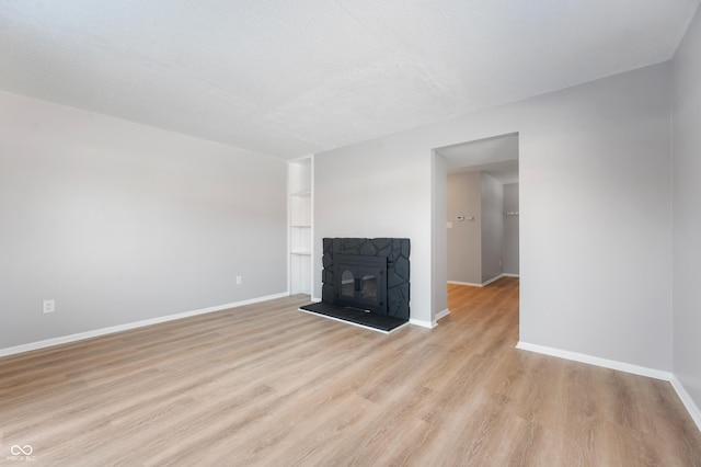 unfurnished living room with a textured ceiling and light wood-type flooring