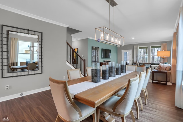 dining space featuring dark wood-type flooring and crown molding