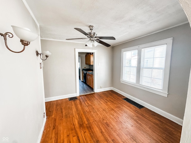 unfurnished living room with ceiling fan, a textured ceiling, and dark hardwood / wood-style floors