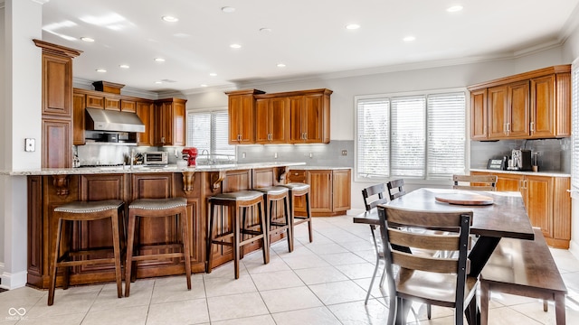 8526 Oakmont Ln, Indianapolis, IN 46260 - kitchen featuring light tile patterned floors, crown molding, light stone countertops, and backsplash