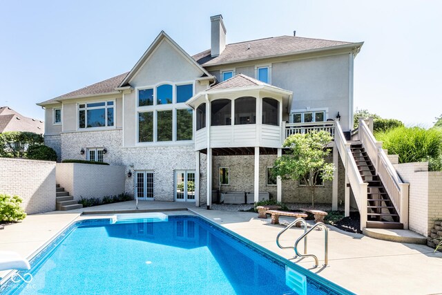 8526 Oakmont Ln, Indianapolis, IN 46260 - rear view of house with a swimming pool with hot tub, a patio area, a sunroom, and french doors