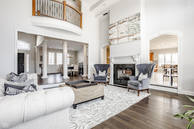 8526 Oakmont Ln, Indianapolis, IN 46260 - living room featuring decorative columns, wood-type flooring, a healthy amount of sunlight, and a fireplace