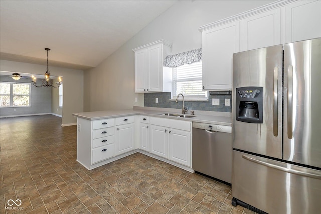 kitchen with white cabinetry, sink, kitchen peninsula, and appliances with stainless steel finishes