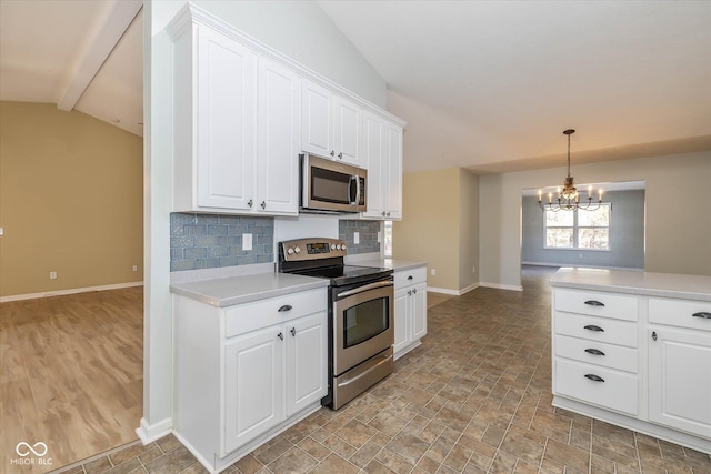 kitchen with white cabinetry, stainless steel appliances, decorative light fixtures, and backsplash