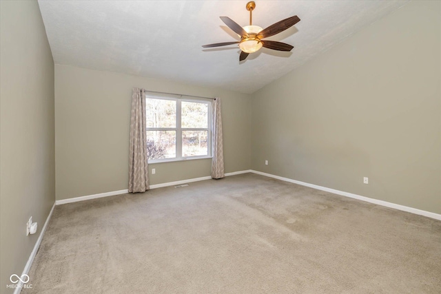 empty room with ceiling fan, light colored carpet, and lofted ceiling