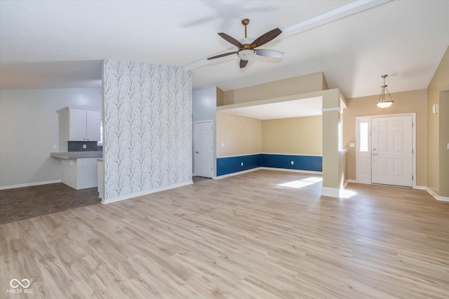 unfurnished living room with ceiling fan, lofted ceiling, and light hardwood / wood-style floors