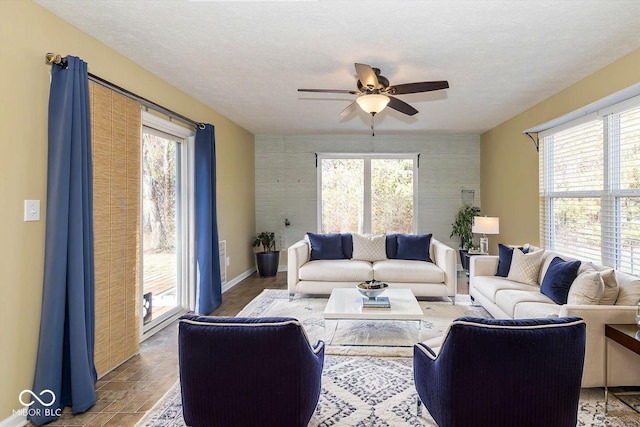 living room featuring ceiling fan and a textured ceiling