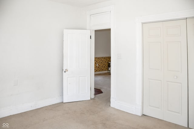 unfurnished bedroom featuring a closet and light carpet