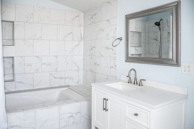 bathroom with tiled shower / bath, vanity, and lofted ceiling