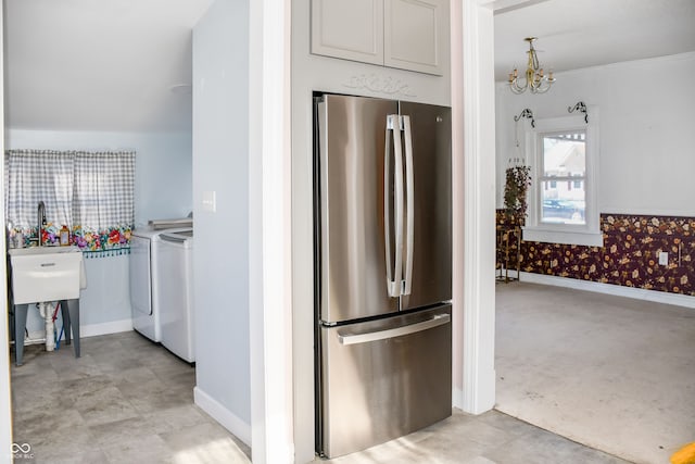 kitchen with washing machine and dryer, stainless steel fridge, and a chandelier