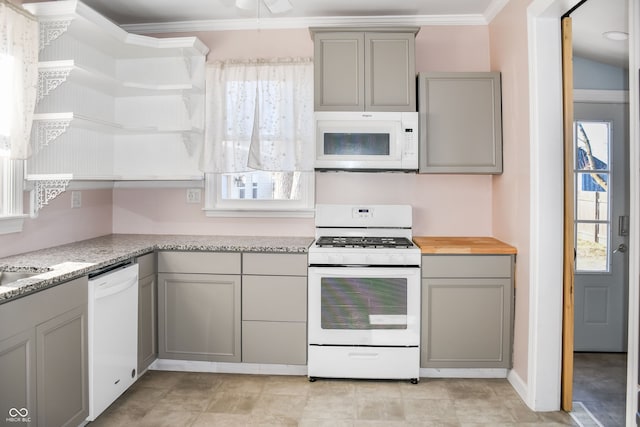 kitchen with white appliances, ornamental molding, gray cabinets, and light stone countertops