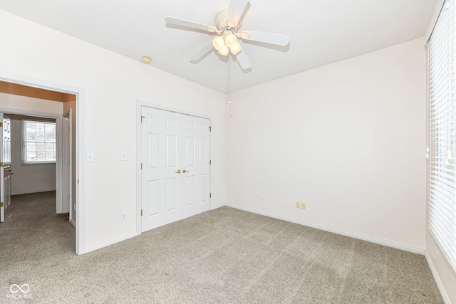 unfurnished bedroom featuring light carpet, ceiling fan, and a closet