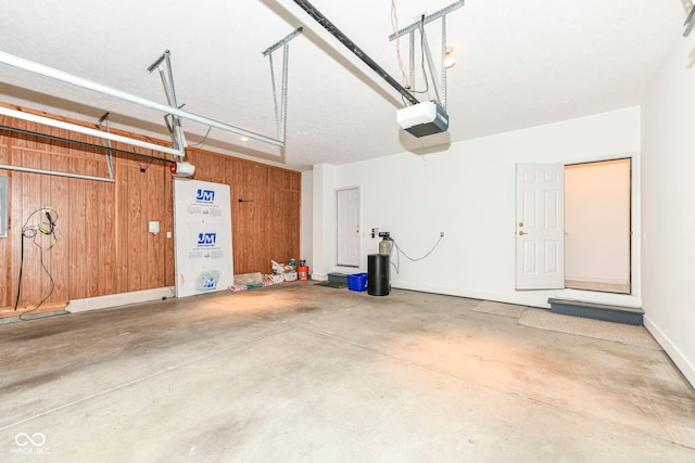 garage featuring a garage door opener and wooden walls