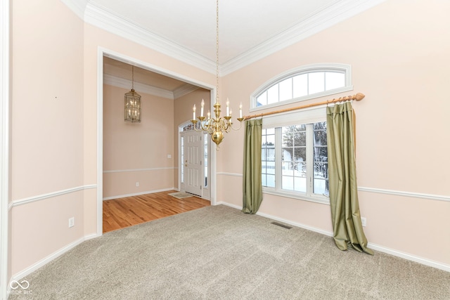 carpeted spare room featuring crown molding and a notable chandelier