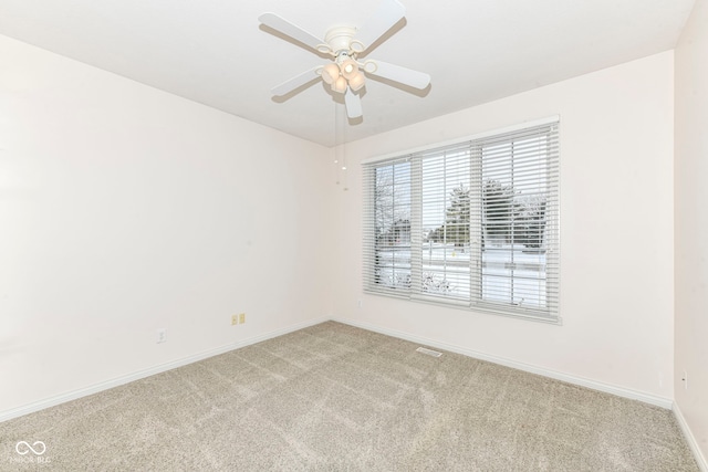 carpeted spare room featuring ceiling fan