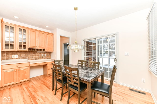 dining room featuring light wood-type flooring and a notable chandelier