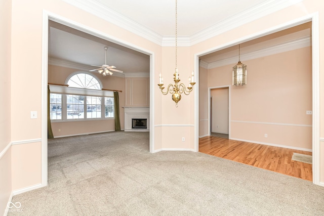 unfurnished living room with ceiling fan, carpet, and ornamental molding