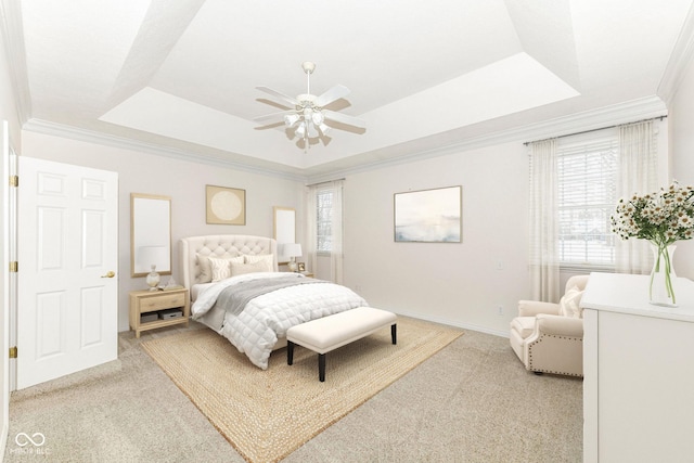 carpeted bedroom with ceiling fan, a tray ceiling, and multiple windows