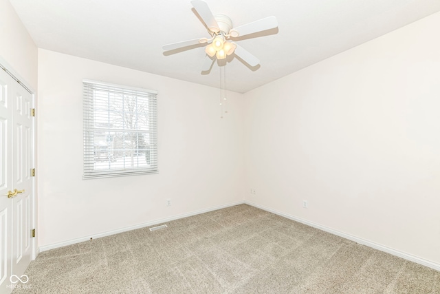 carpeted empty room featuring ceiling fan