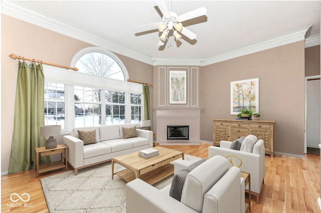 living room featuring ceiling fan, ornamental molding, and light hardwood / wood-style floors