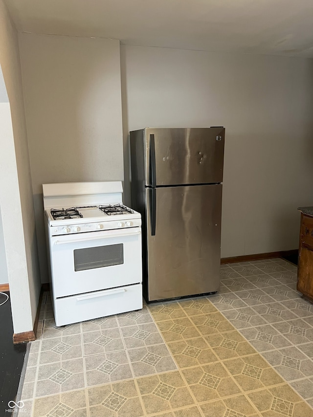 kitchen with stainless steel refrigerator and white gas range oven