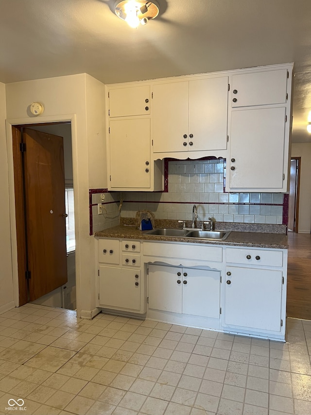 kitchen with white cabinetry, tasteful backsplash, and sink